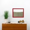 red painted wood frame ant farm hanging on wall