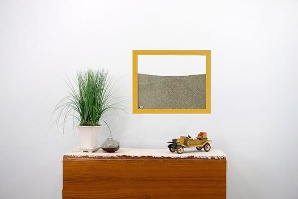 yellow wood frame ant farm hanging on wall